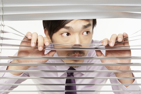 22833718-businessman-peeking-through-window-blinds.jpg