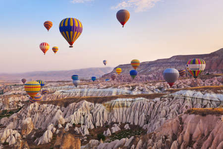 balloon: Hot air balloon flying over rock landscape at Cappadocia Turkey Stock Photo