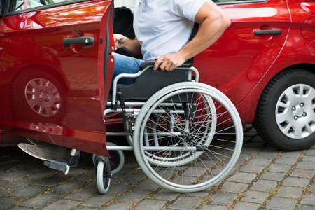 disability: Close-up Of A Disabled Man In Wheelchair Getting In His Car
