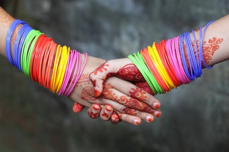 Bangles 23296978 shaking hands decorated with colorful bracelets and henna tattoo - Bangles