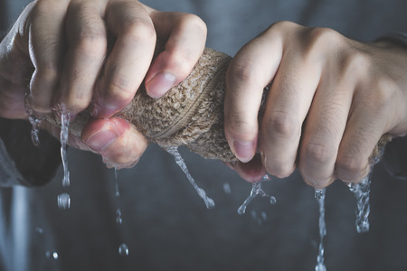 64917071-hands-of-men-who-squeeze-towel.