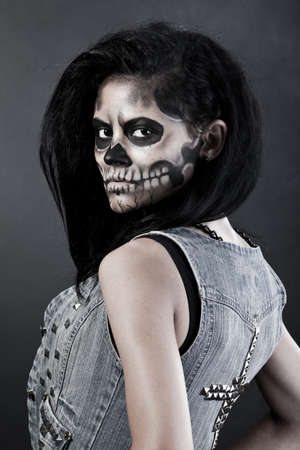 15762304-young-woman-in-day-of-the-dead-mask-skull-face-art-halloween-face-art-with-fog-on-black-background.jpg