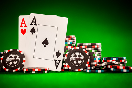 poker: Stack of chips and two aces on the table on the green baize - poker game concept