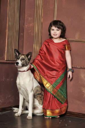 Niña tiene un traje nacional de la India, con su perro. Foto de archivo. Niña tiene un traje nacional de la India, con su perro. Foto de archivo.