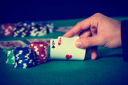 poker: Closeup of poker player with two aces in pastel colors Stock Photo