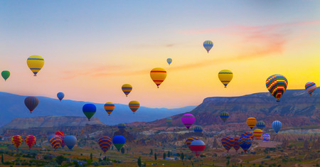 balloon: sunset Hot air balloons landing in a mountain Cappadocia Goreme National Park Turkey.