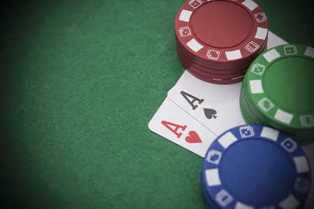 poker: two Ace of pokers beside lots of chips on casino table