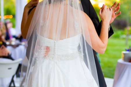 A bride and groom share their first dance on the dance floor at their wedding reception. Stock Photo