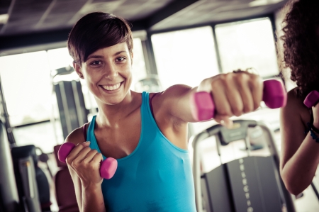 Running on treadmill in gym or fitness club - group of women and men exercising to gain more fitness