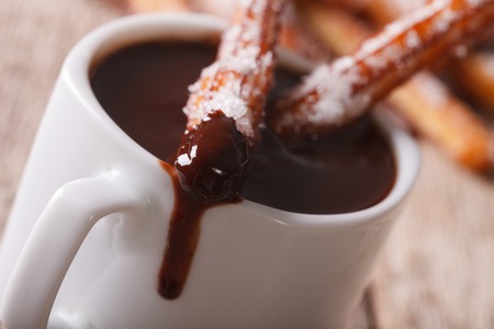 churros con chocolate: Churros españoles con una taza de chocolate caliente una macro en la mesa
