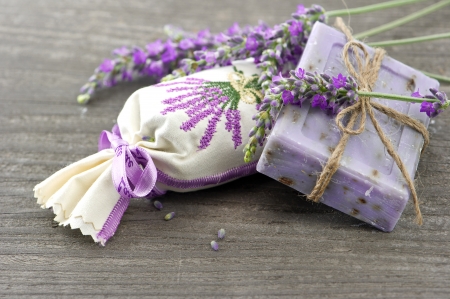 BOLSITAS PERFUMADAS: Primer plano de jabón de lavanda y perfumadas bolsitas con flores frescas sobre fondo de madera Foto de archivo