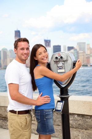 Happy romantic dating interracial couple sightseeing looking at Manhattan and New York City skyline from Ellis Island