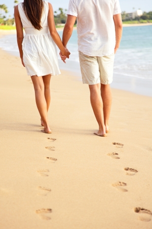 Couple%20holding%20hands%20walking%20romantic%20on%20beach%20on%20vacation%20travel%20holidays%20leaving%20footprints%20in%20the%20sand.%20Closeup%20of%20feet%20and%20golden%20sand%20for%20copy%20space.%20Young%20couple%20wearing%20white%20shorts.%20Stock%20Photo%20-%2020560047