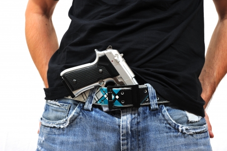19054379-man-with-gun-tucked-into-the-waistband-of-his-trousers.jpg