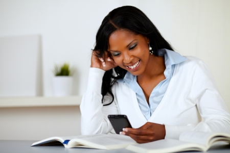 Portrait of a pretty lovely woman smiling and reading a cellphone message at soft colors composition