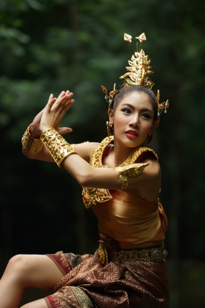 Belle dame thaïlandaise en robe de théâtre traditionnel thaï, posant dans la forêt, de la verdure dans le fond, le modèle est Thaïlandais. Banque d'images - 22062899