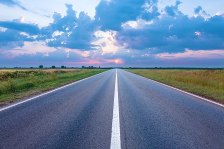 La carretera de asfalto hacia el sol naciente photo