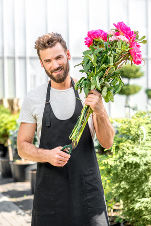 J - 2 60995221-fleur-beau-vendeur-faisant-un-beau-bouquet-de-pivoines-roses-dans-le-magasin-de-fleurs
