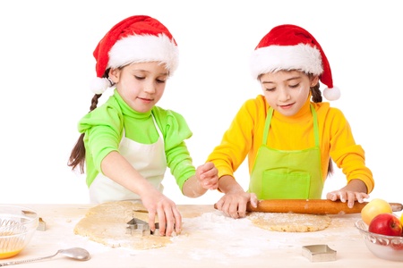 Dos niñas sonrientes con la cocina de Navidad, aislado en blanco Foto de archivo. Dos niñas sonrientes con la cocina de Navidad, aislado en blanco Foto de archivo.