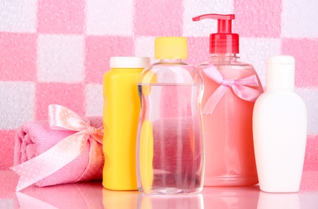 Baby Cosmetics And Towel In Bathroom On Pink Tile Wall Background ...