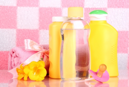 Baby Cosmetics And Towel In Bathroom On Pink Tile Wall Background ...