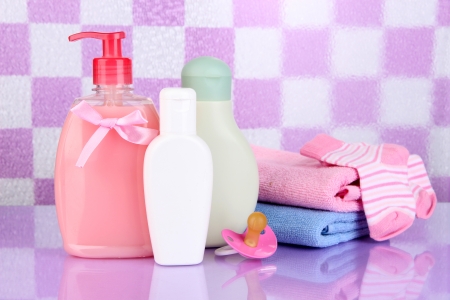 Baby Cosmetics And Towel In Bathroom On Pink Tile Wall Background ...