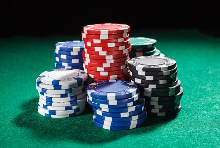 poker: chips for poker on green playing table