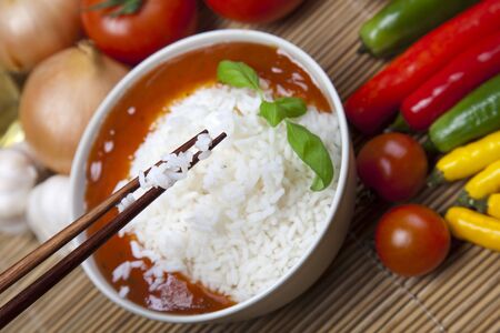 A bowl of perfectly cooked, plain Basmati rice, in an Asian style bowl, with a garnish of Thai Basil
