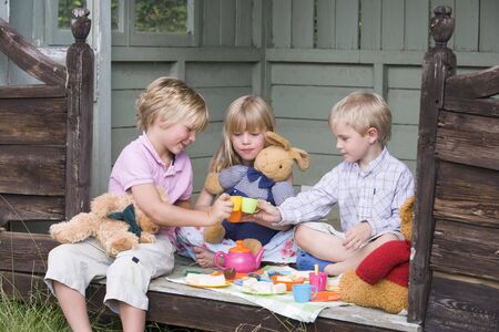 3475480-three-young-children-in-shed-playing-tea-and-smiling.jpg