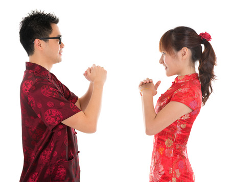 Side view Asian man and woman with Chinese traditional dress cheongsam. Chinese new year concept, isolated on white background. Stock Photo Side view Asian man and woman with Chinese traditional dress cheongsam. Chinese new year concept, isolated on white background. Stock Photo - 22284186