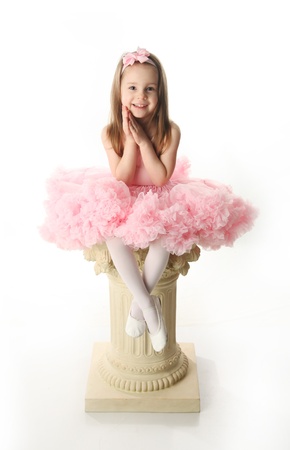 Portrait of an adorable preschool age girl playing dress up wearing a ballet tutu, isolated on white
