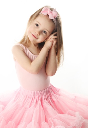 Portrait of an adorable preschool age girl playing dress up wearing a ballet tutu, isolated on white