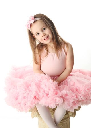 Portrait of an adorable preschool age girl playing dress up wearing a ballet tutu, isolated on white