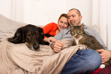 http://us.123rf.com/450wm/tibanna79/tibanna791505/tibanna79150500010/40192481-a-couple-lying-with-her-dog-and-her-cat-on-the-sofa.jpg?ver=6