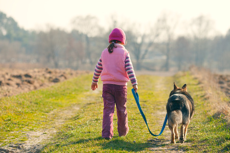 Niña que recorre el campo con su perro. Foto de archivo. Niña que recorre el campo con su perro. Foto de archivo.