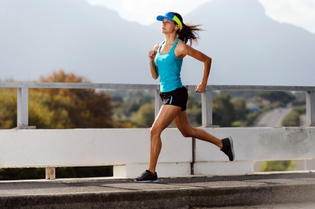 female runner: Athlete running on bridge. action shot of runner in mid air. healthy lifestyle fitness woman Stock Photo