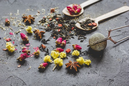 Spoons and herbs on grey stone background Stock Photo