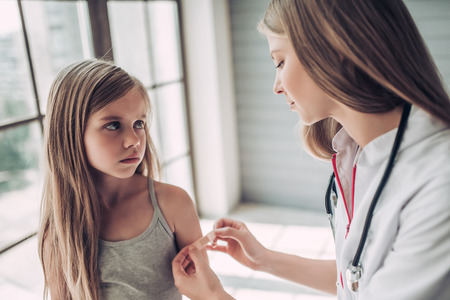 医師小児科医でかわいい女の子の画像をトリミングしました 絆創膏を使用しています の写真素材 画像素材 Image