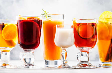 Selection Of Autumn Or Winter Alcoholic Hot Drinks And Cocktails - Mulled Wine, Glogg, Grog, Eggnog, Warm Ginger Ale, Hot Buttered Rum, Punch, Mulled Apple Cider On Gray Background, Copy Space