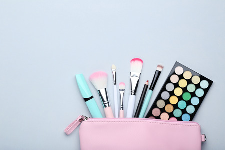 Different makeup cosmetics on grey background