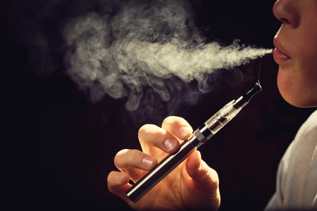 Close up of a man inhaling from an electronic cigarette.