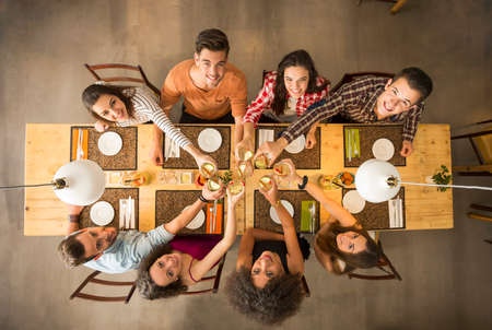 Gruppe von Personen, die ein Restaurant Foto glücklich anstößt und betrachtet