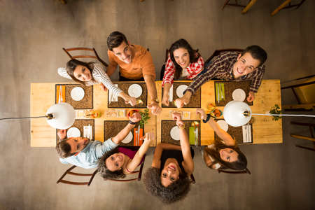 Gruppe von Personen, die ein Restaurant Foto glücklich anstößt und betrachtet