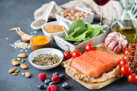バランスの取れた食事食品のコンセプト 健康食品低コレステロール ほうれん草アボカド赤ワイン緑茶サーモン トマト果実亜麻嘉種ウコンにんにくナッツ オリーブ オイルの品揃え の写真素材 画像素材 Image 82622389