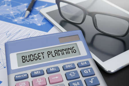 budget planning calculator on table with office supplies ipad stock budget planning calculator
