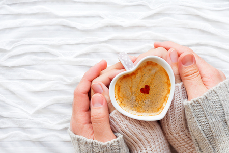 女と男は シナモンの心でホット コーヒーのカップを保持します スパーク リングの赤と銀の紙吹雪とファブリックの背景の冬とバレンタインの日 の写真素材 画像素材 Image