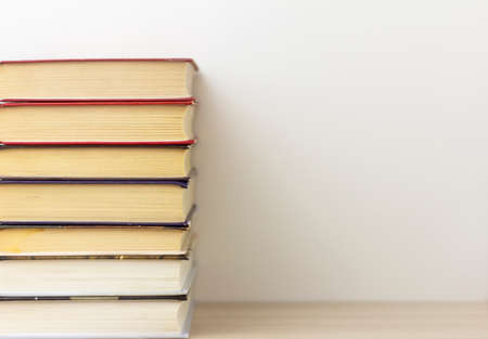 Books a stack of neatly stacked books on a table or shelf with a copy of the space