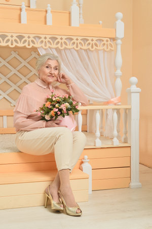 Happy Senior Woman At Home With Flowers