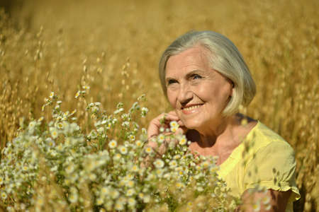 Portrait Of Happy Senior Woman With Flowers