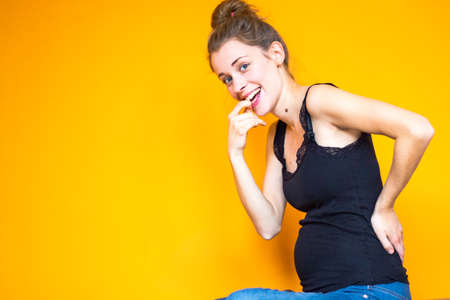 orange background girl with black top Stock Photo